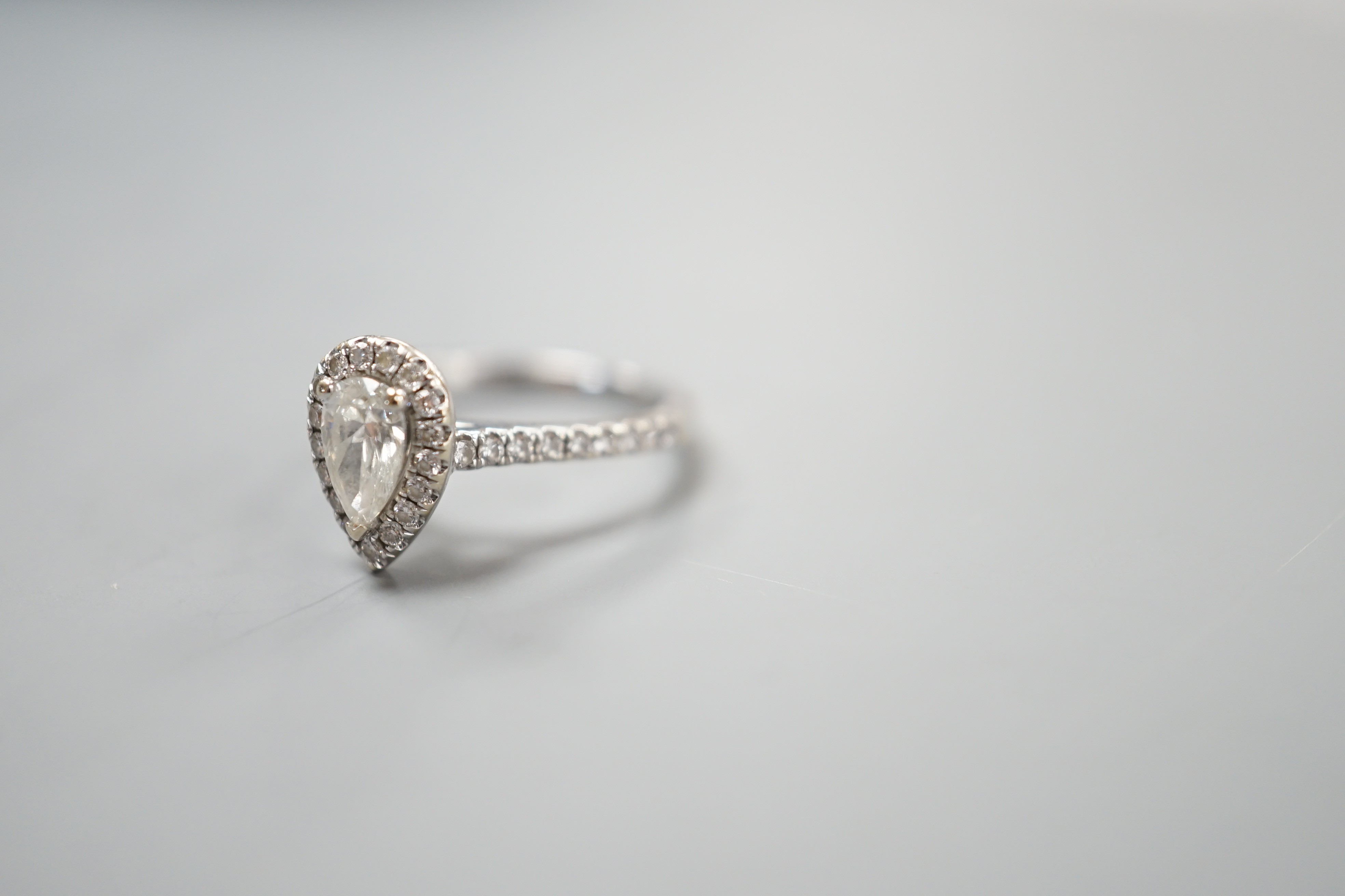 A modern '77 Diamonds' 18ct white gold and singe stone pear cut diamond set ring bordered with brilliants, with GIA report date 29/12/2016 stating the single stone to weigh 0.50ct with a colour and clarity of I and VS1,